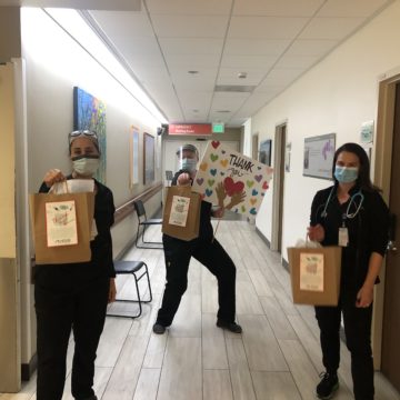 3 nurses holding PME care packages in hospital hall