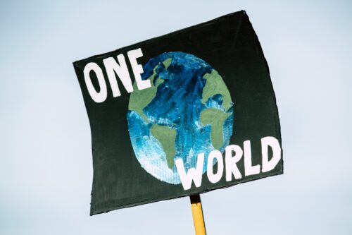 Graphic of a sign stating, "ONE WORLD."