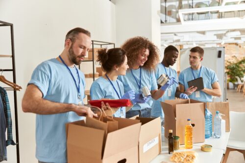 Diverse team of volunteers assembling care packages.